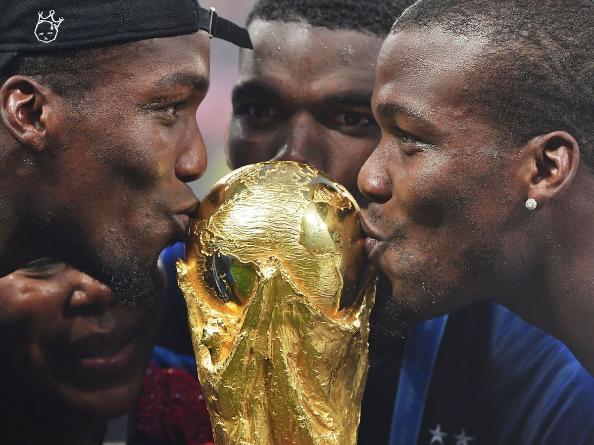 Foto: Paul Pogba besa la Copa del Mundo junto a su hermano Mathias. (EFE/Peter Powell)