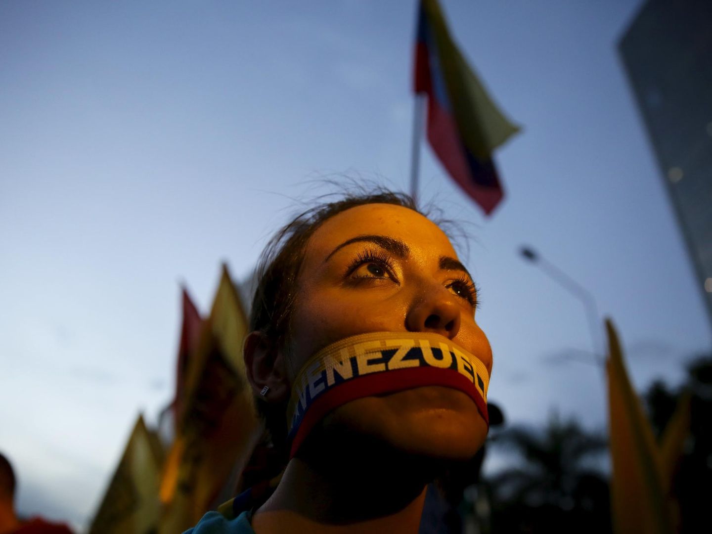 Una opositora con una pegatina con los colores de la bandera venezolana en la boca durante el cierre de campaña en Caracas (Reuters).