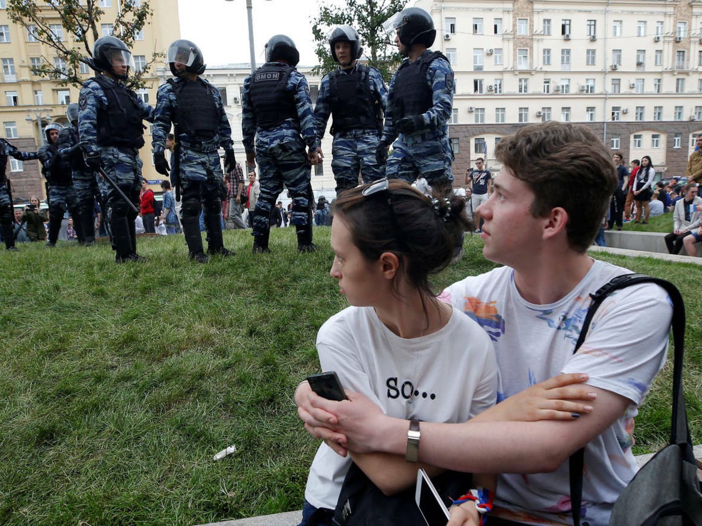Dos jóvenes miran a unos agentes antidisturbios durante una protesta anticorrupción en Moscú, el 12 de junio de 2017. (Reuters)