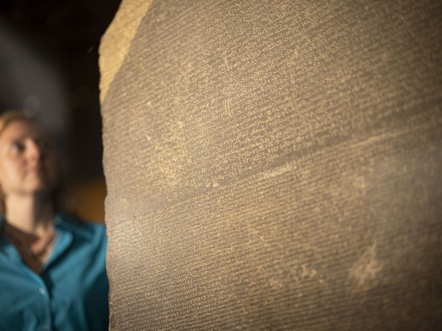 Una egiptóloga revisando la Piedra Rosetta en Londres. (EFE)    