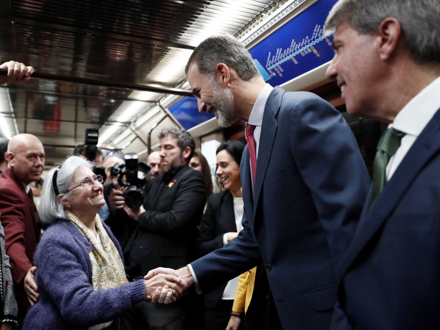 El rey Felipe saluda a una mujer durante el recorrido en metro entre las estaciones de Sol y Chamartín, en el acto conmemorativo del centenario de la puesta en funcionamiento de la primera línea de metro de Madrid, este 17 de octubre. (EFE)
