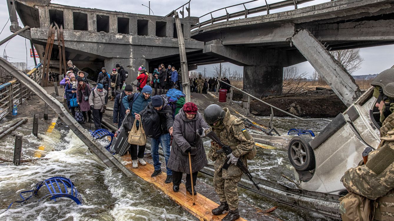 Foto: Familias ucranianas huyen del puente de Irpin, en la región de Kiev. (EFE/Roman Pilipey)