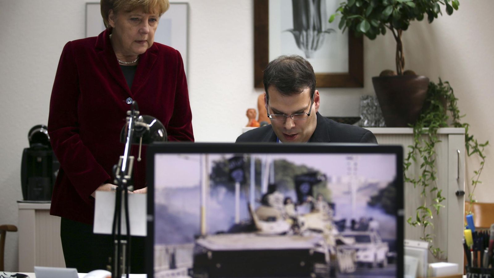 Foto: La canciller Merkel observa el trabajo de un agente del BfV, los servicios secretos internos alemanes, en su cuartel general en Colonia, en octubre de 2014. (Reuters)