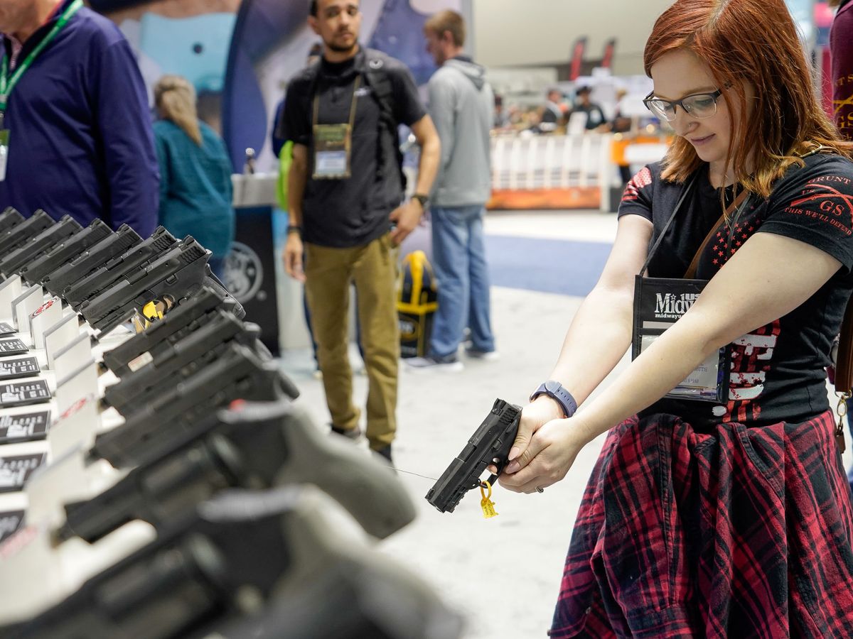 Foto: Una mujer sostiene una pistola durante el foro anual de la Asociación Nacional del Rifle (NRA) en 2019. (Reuters/Bryan Woolston)