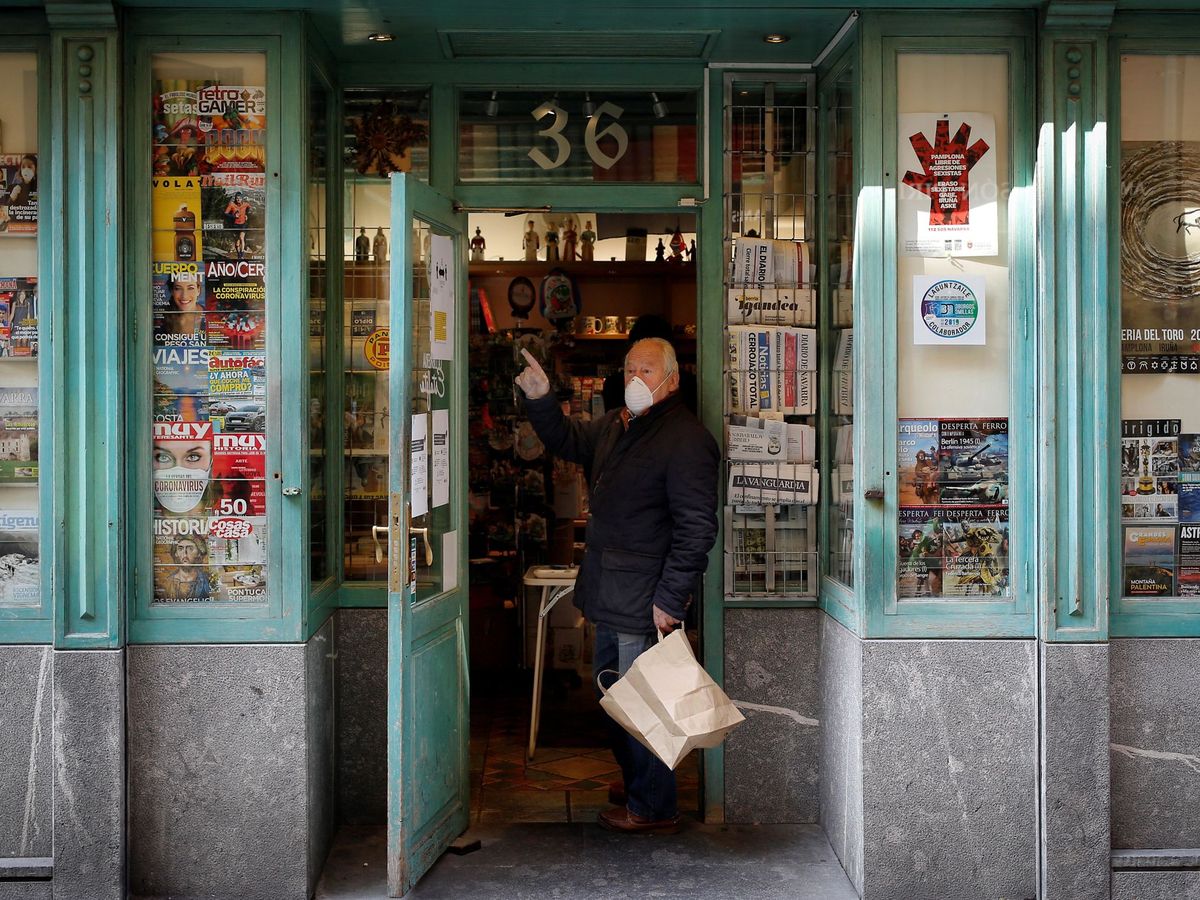 Foto: Un hombre con mascarilla en la puerta de una establecimiento que vende prensa (EFE)