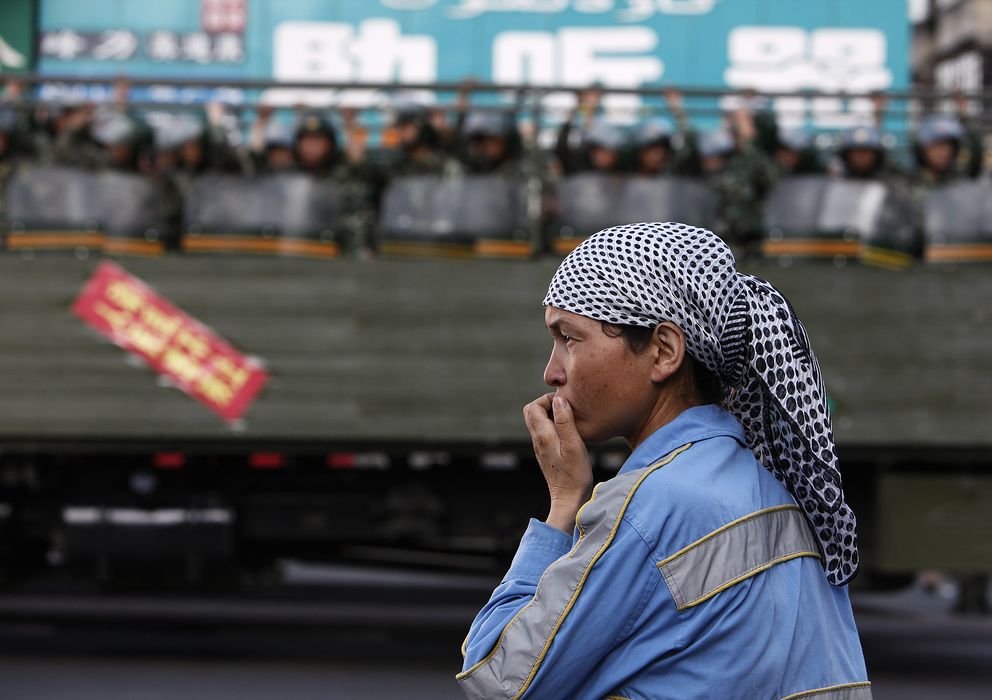 Foto: Una mujer uigur ante un camión de la policía paramilitar china en Urumqi, capital de la provincia de Xinjiang (Reuters)
