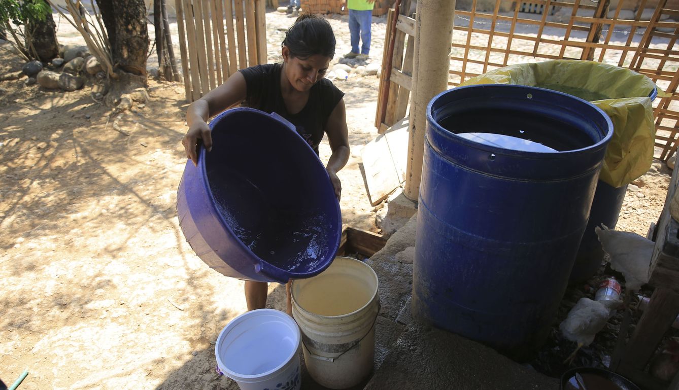 Una mujer recoge agua en Honduras durante una sequía en 2018. (Efe)