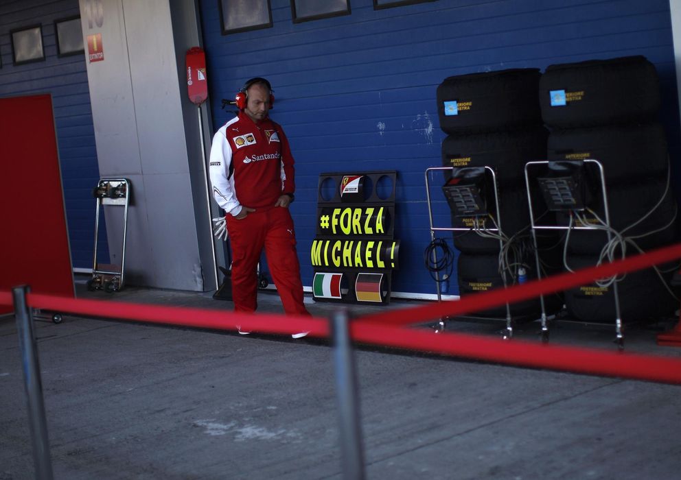 Foto: Un trabajador de Ferrari pasa junto al cartel que da ánimos al alemán, en Jerez.