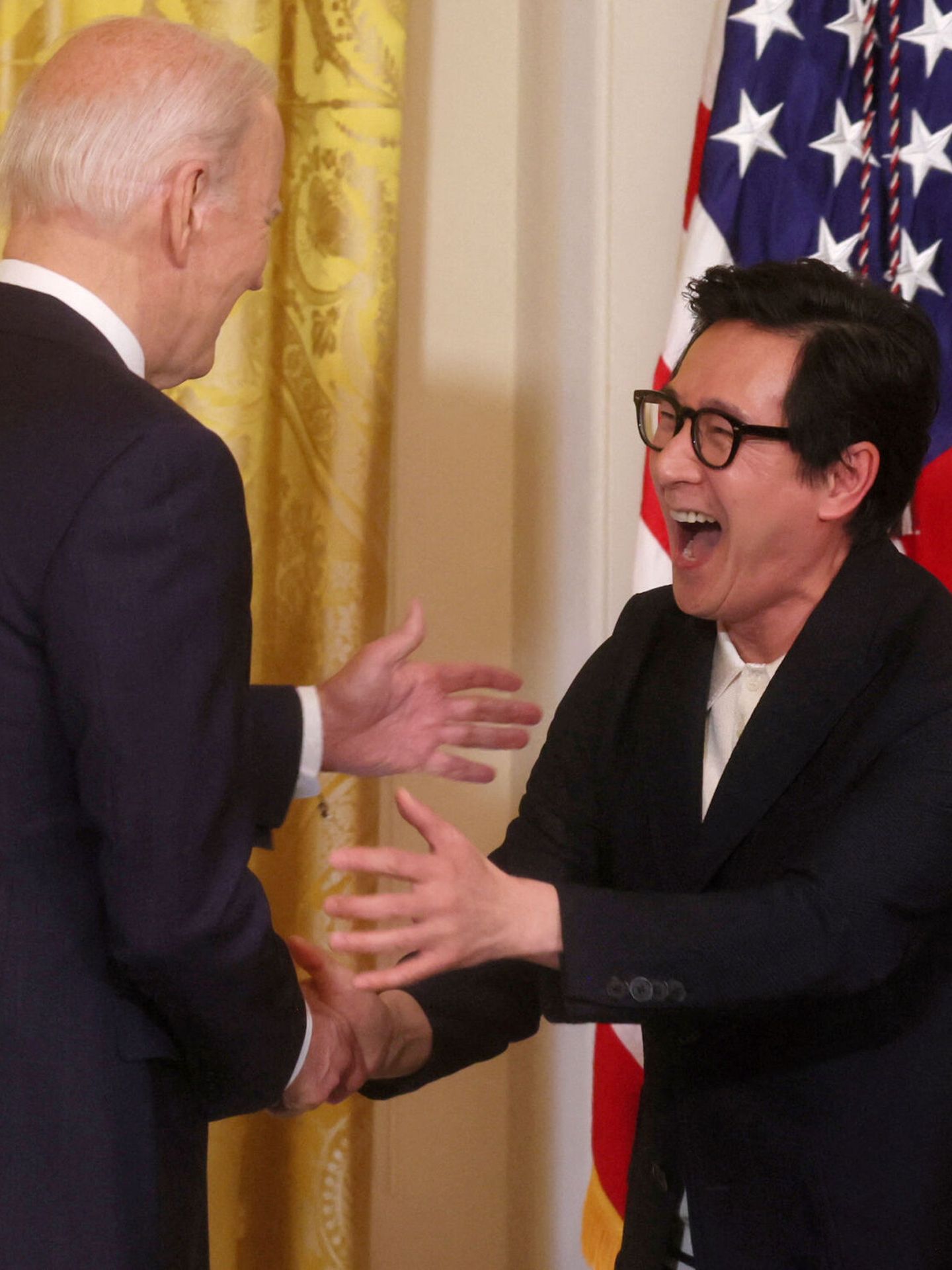 Ke Huy Quan saluda a Joe Biden.  (Reuters/Leah Millis)