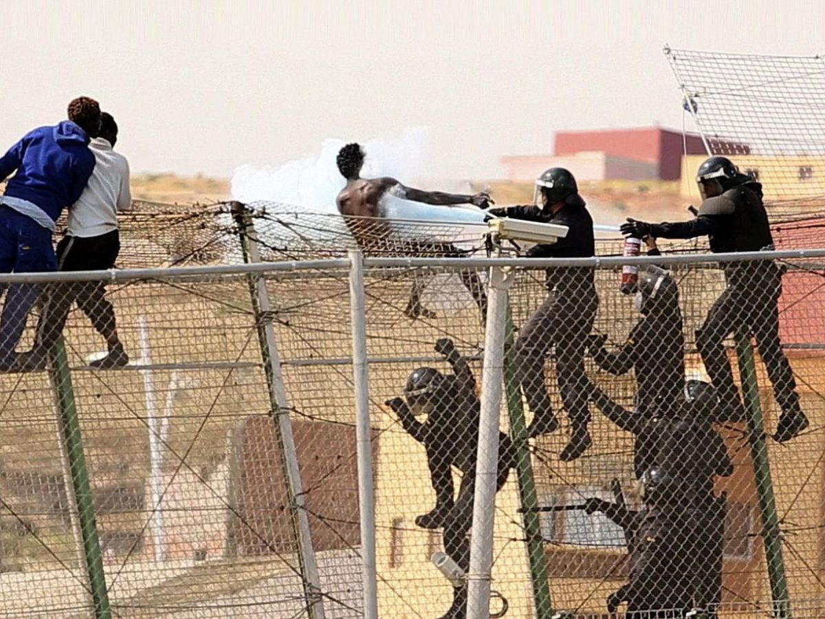 Foto: Miembros de los GRS de la Guardia Civil intervienen cuando decenas de inmigrantes trataban de superar la valla que separa Melilla de Marruecos. (EFE)