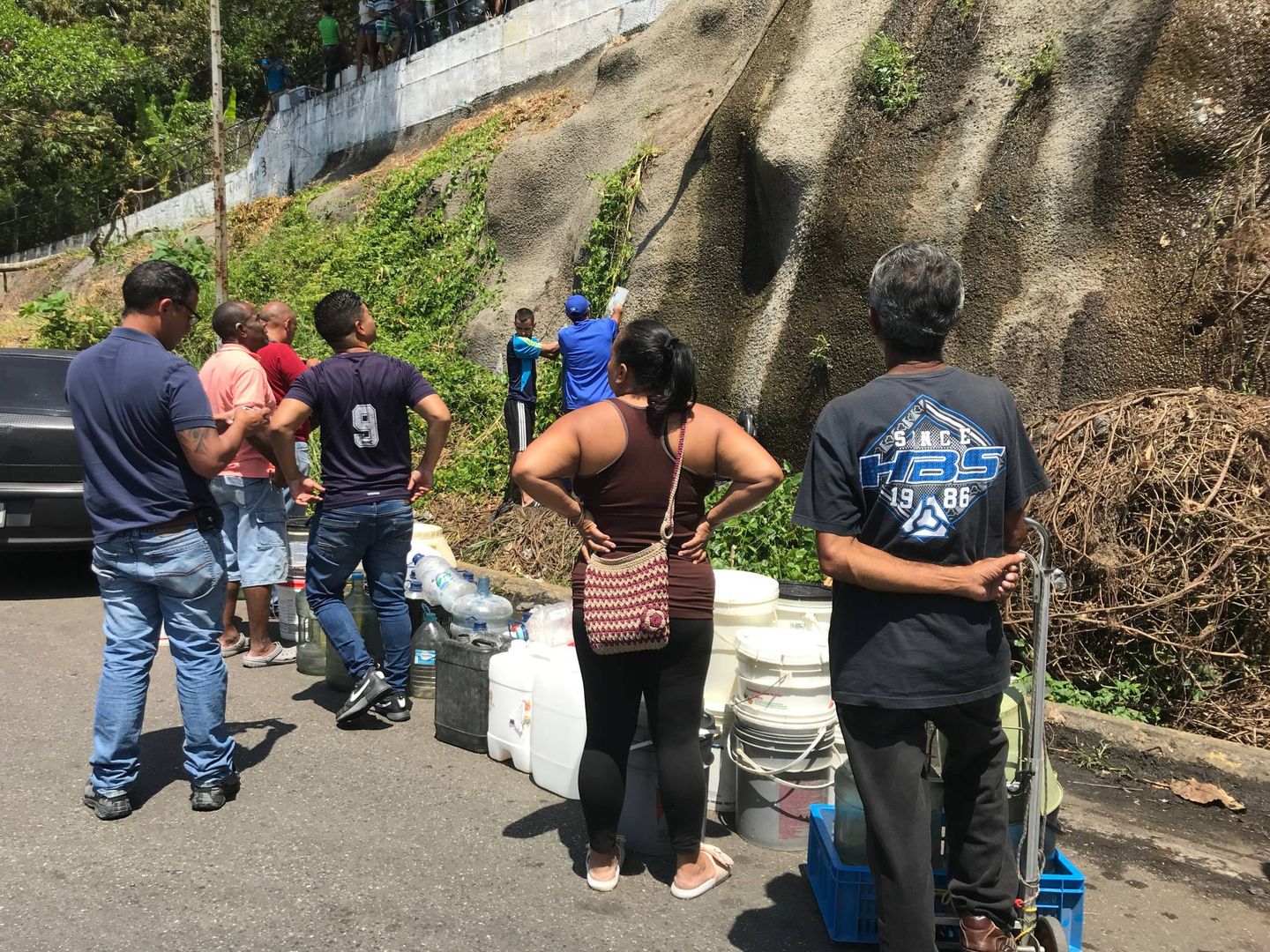 Grupos de personas esperan para recoger agua de los manantiales del Ávila. (A. Hernández)