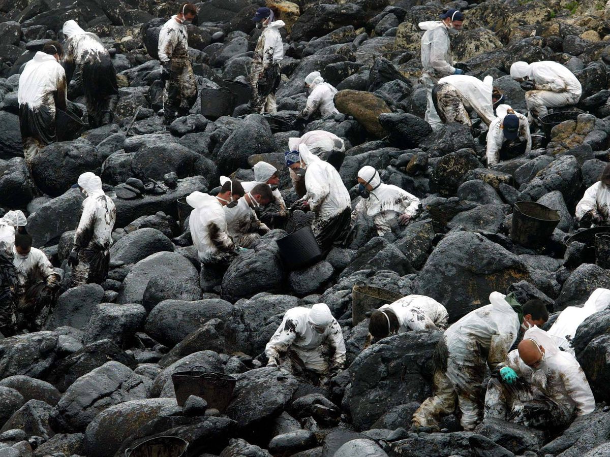 Foto: Voluntarios limpiando en 2002 el chapapote que provocó el petrolero Prestige en la costa gallega.