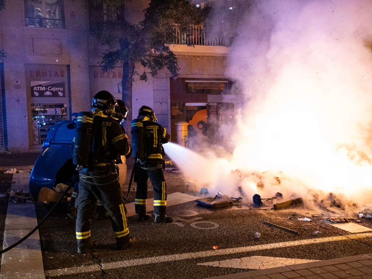 Foto: Un grupo de bomberos apaga una barricada en Ferraz durante la nueva protesta contra la amnistía. (Sergio Beleña)