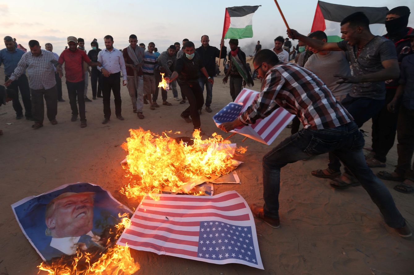 Manifestantes palestinos queman retratos de Donald Trump y banderas de EEUU durante la conmemoración del 70º aniversario de la Nakba, el 15 de mayo de 2018. (Reuters)