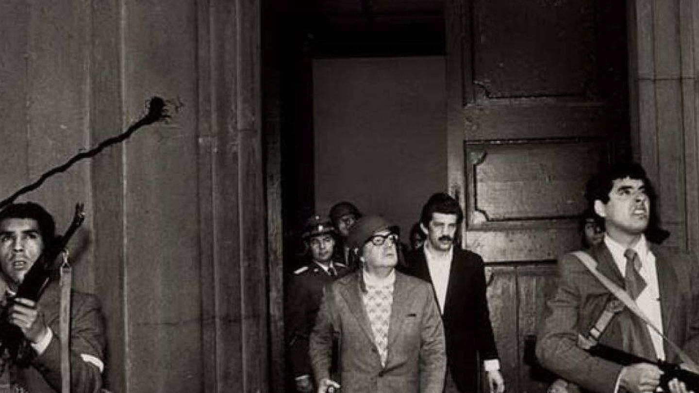 Salvador Allende, con casco y un fusil en la mano, junto a un grupo de fieles durante la resistencia en el Palacio de la Moneda.