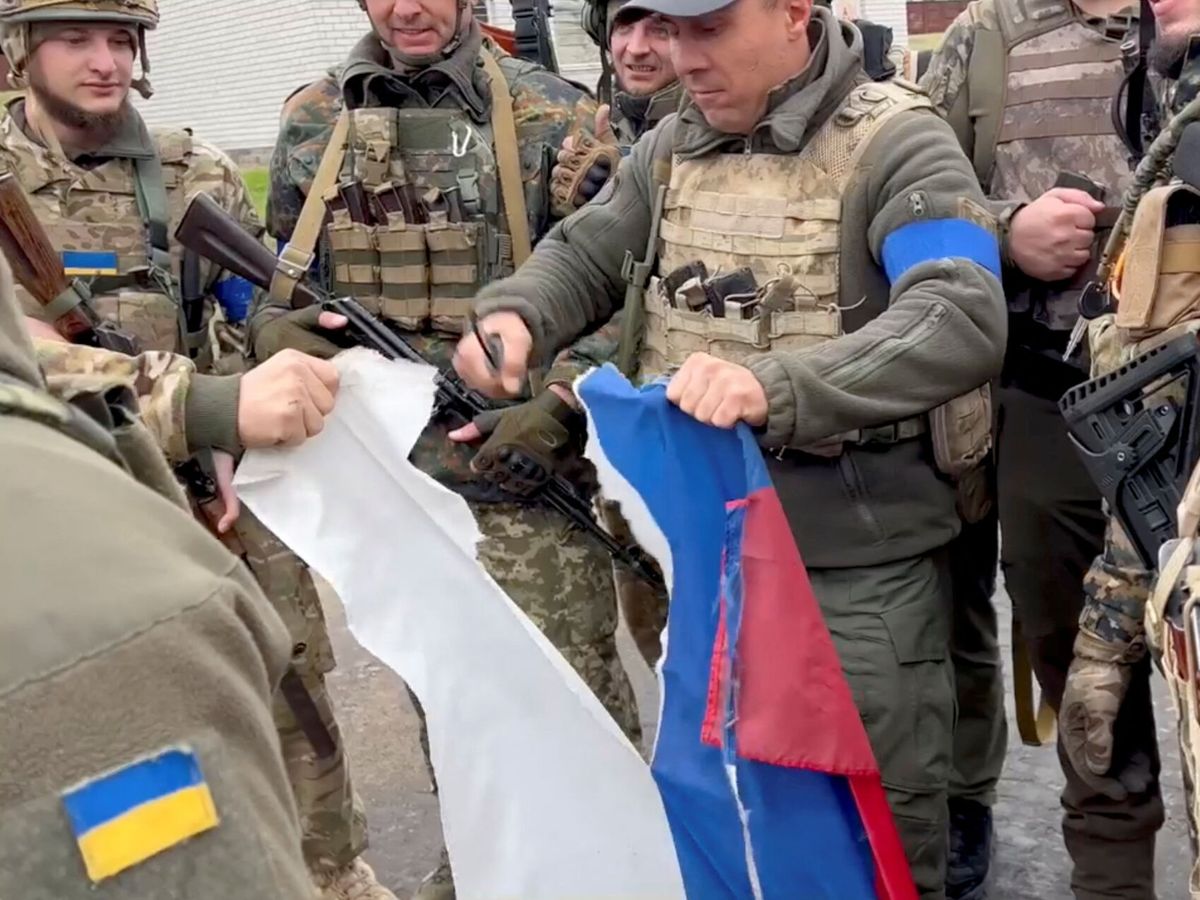 Foto: El alcalde del distrito de Derhachi, Vyacheslav Zadorenko, rompe en pedazos una bandera rusa en Kozacha Lopan, Ucrania. (Reuters)