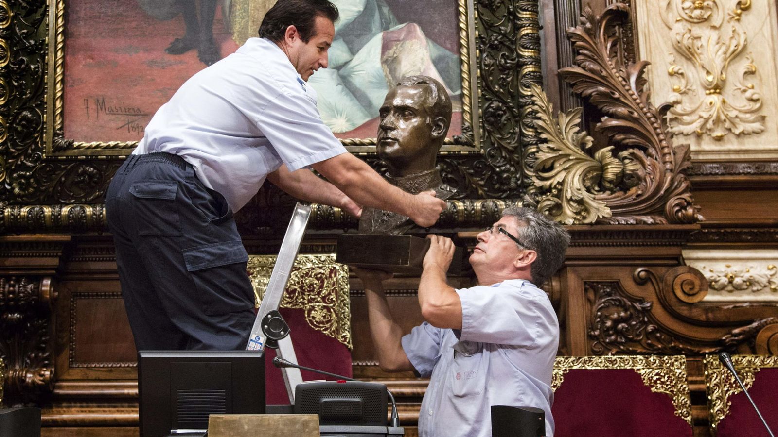 Foto: Dos operarios retiran el busto de Juan Carlos I del salón de plenos de Barcelona. (Efe) 