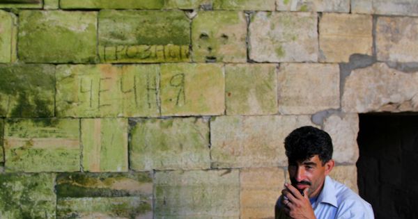 Foto: Sadri, el sirio que custodia el Crac de los Caballeros. Tallado en la pared, un mensaje de los yihadistas: "Grozni. Chechenia". (Ángel Martínez) 