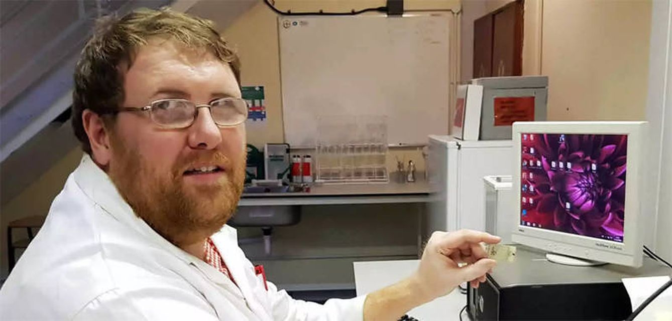 Uno de los investigadores, con el dispositivo entre los dedos (Foto: Strathclyde University)