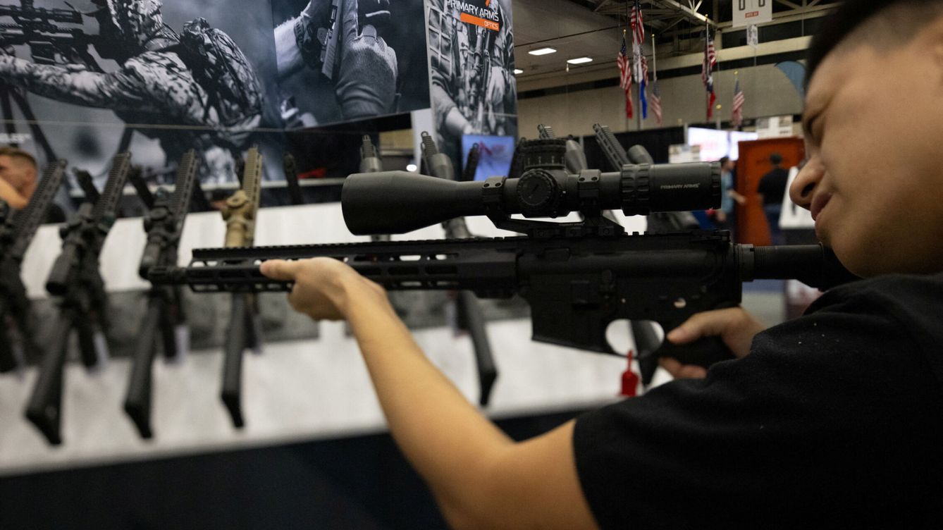 Foto: Un hombre en EEUU sostiene un rifle AR-15 con mira telescópica. (Reuters)