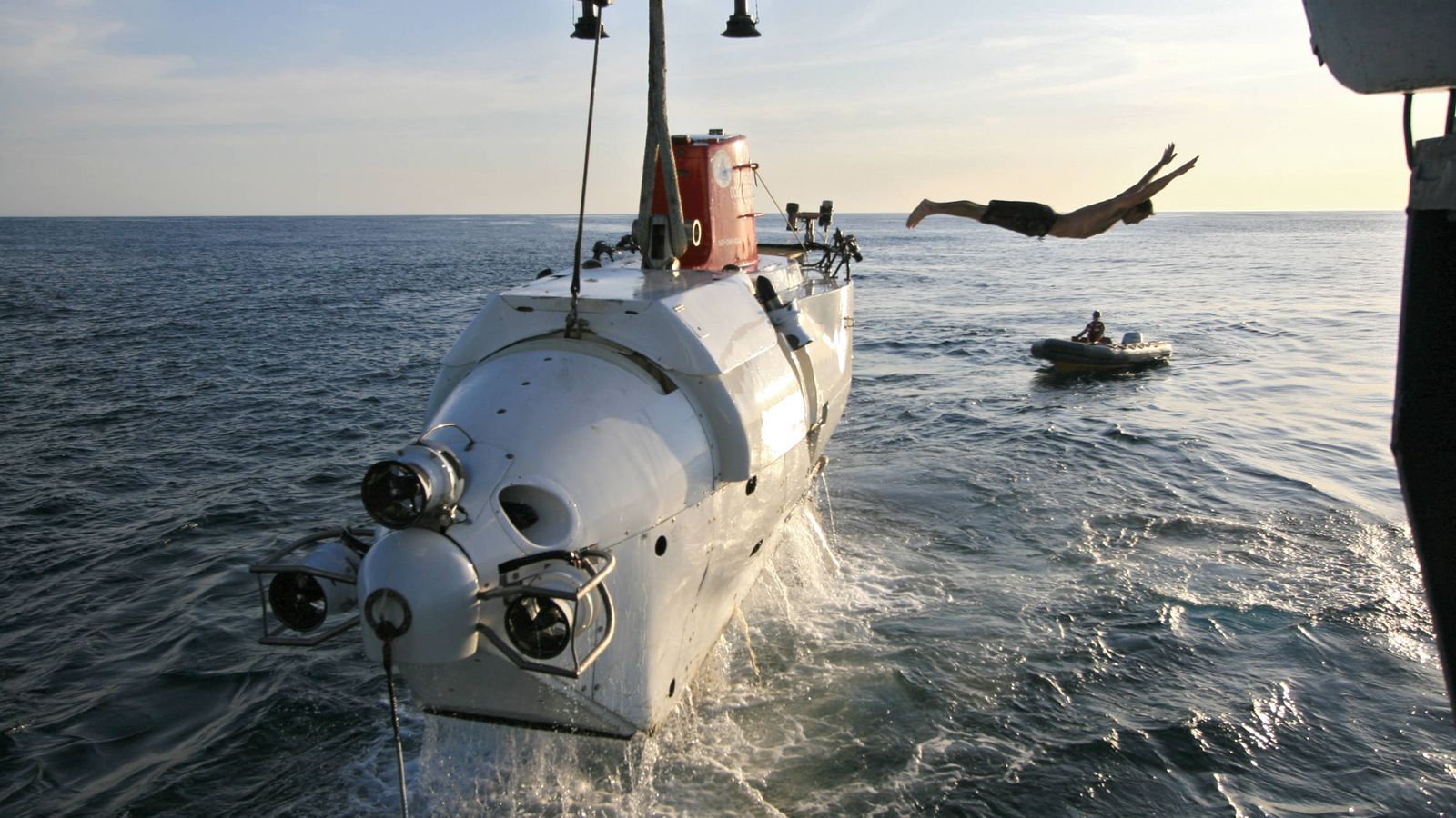 Foto: Uno de los tripulantes de Alvin, un sumergible tripulado para la investigación oceánica profunda, se lanza al agua después de asegurar el submarino a su buque de soporte. (Lance Wills | Woods Hole Oceanographic Institution)