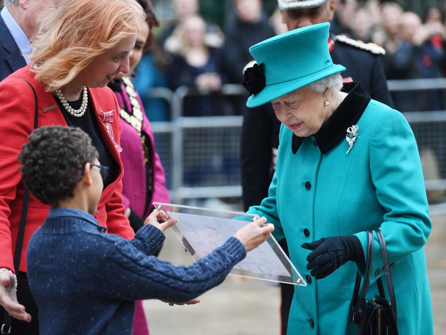 Isabel II de Inglaterra recibe un dibujo de un niño durante la inauguración del centro infantil Queen Elizabeth II de Londres en diciembre de 2018. (EFE)