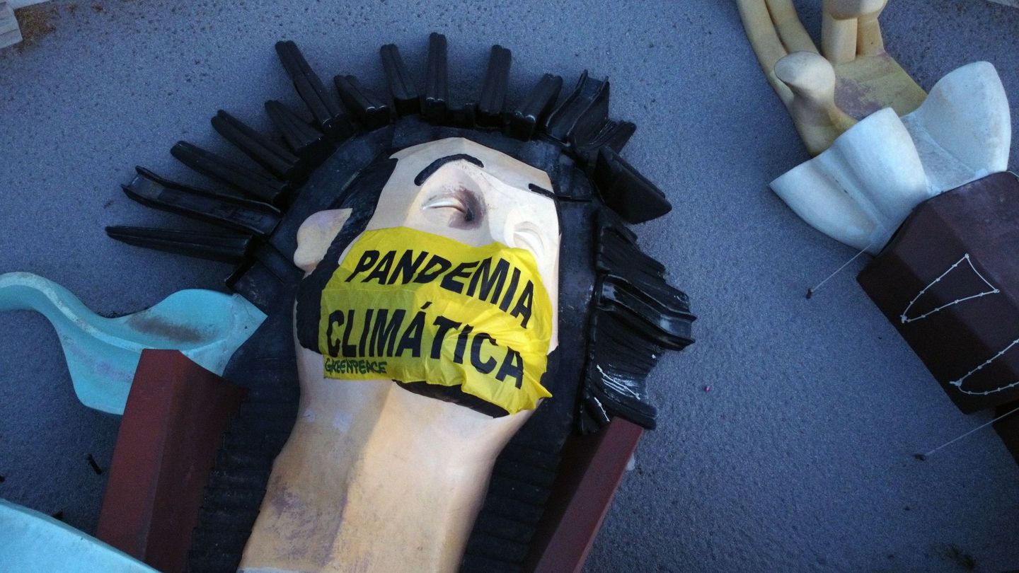 Voluntarios de Greenpeace colocan una mascarilla gigante en la cara de Gulliver. (EFE)