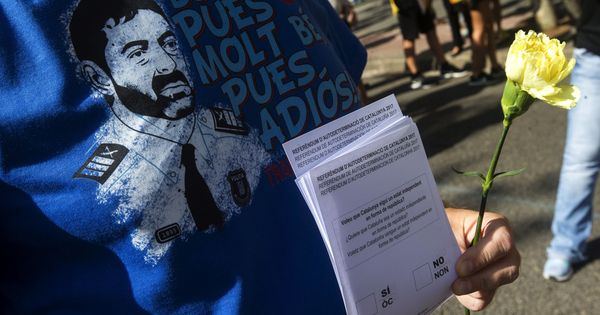 Foto: Una persona con la camiseta del Major de los Mossos Josep Lluis Trapero y papeletas del referéndum. (EFE) 
