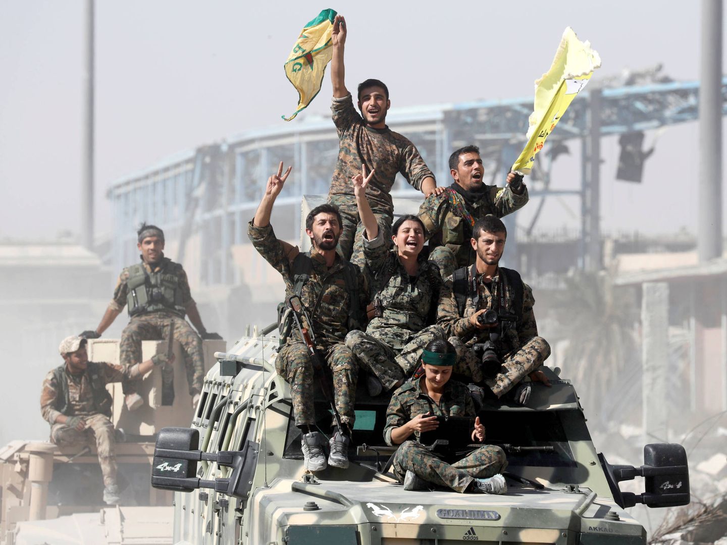 Combatientes de las SDF sobre blindados celebran la victoria en Raqqa, Siria. (Reuters)