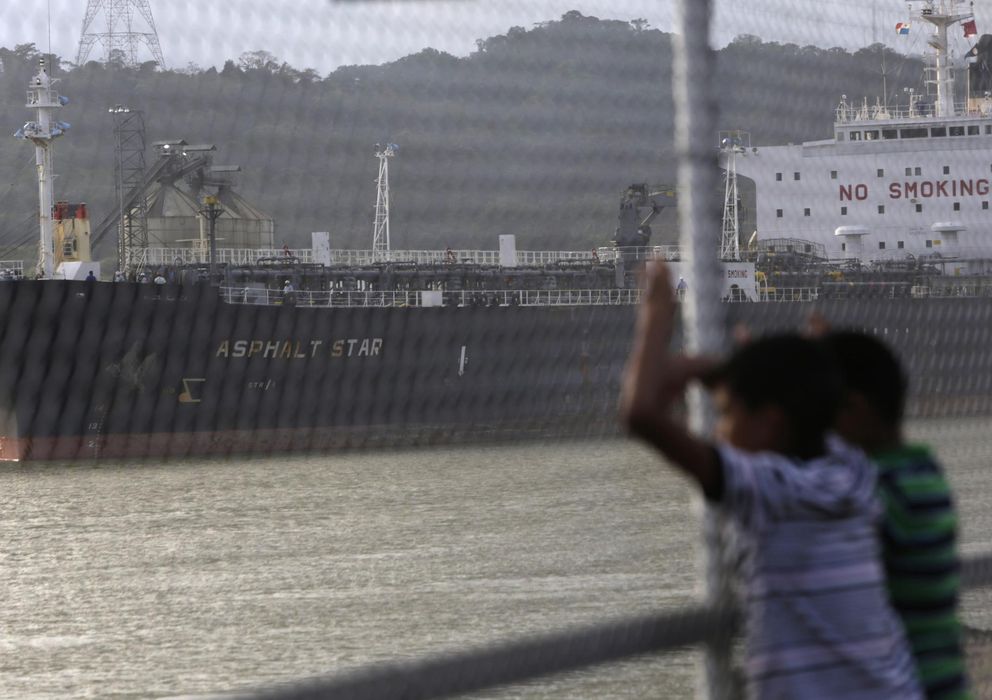 Foto: Dos chicos observan a un carguero transitando por el Canal de Panamá. (Reuters)