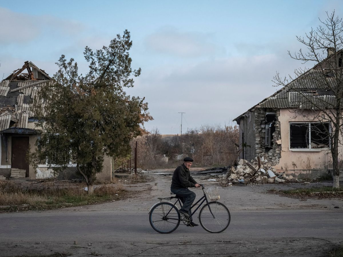 Foto: Un residente local monta en bicicleta cerca de las casas destruidas en el pueblo de Arkhanhelske, en la región de Kherson. (Reuters/Viacheslav Ratynskyi)