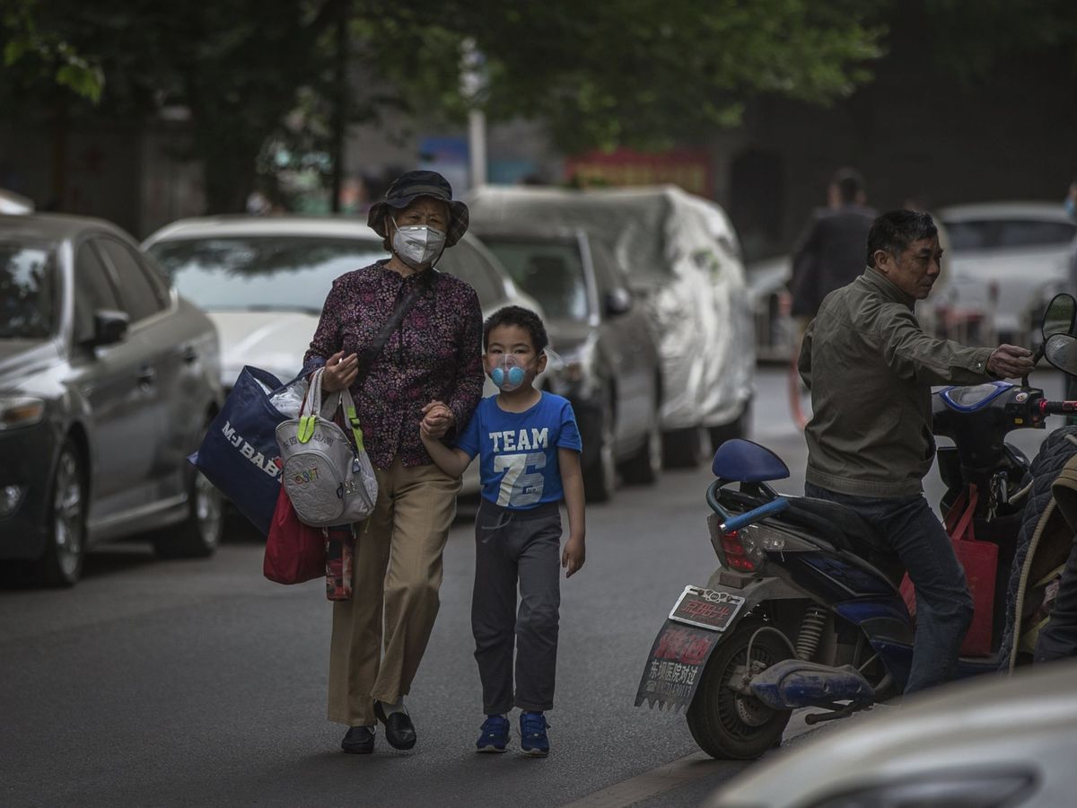 Foto: Un niño y una mujer llevan mascarillas por la contaminación en China. Foto: EFE Wu Hong