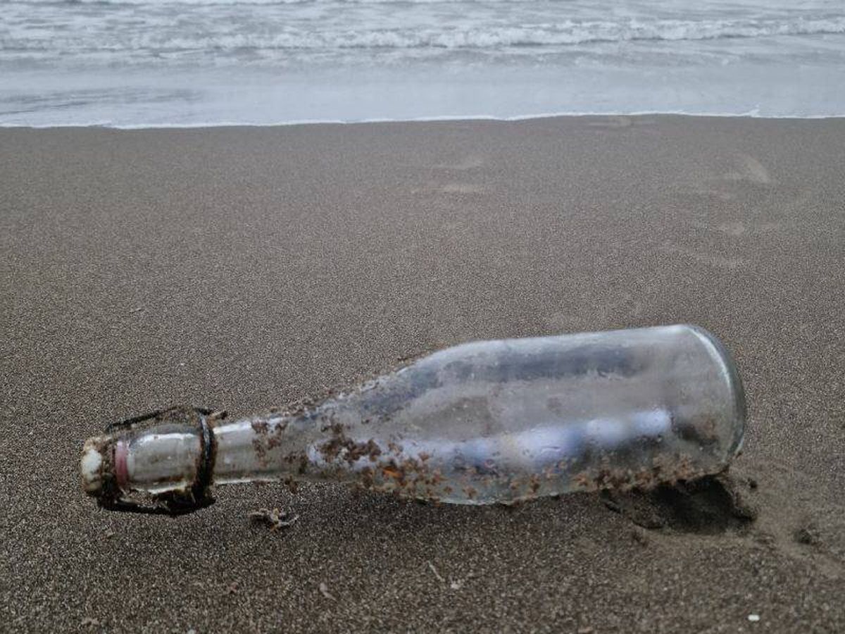 Foto: La botella de cristal que contenía la carta de Tillmann, en la playa de Bacoli (Italia). (Dario Grande/Cedida)