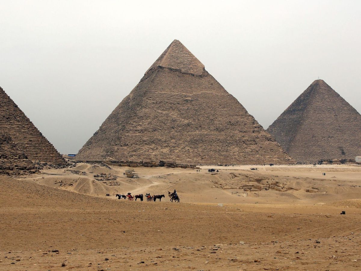 Foto: Turistas disfrutan de un paseo a camello delante de la pirámides en Guiza. (EFE)