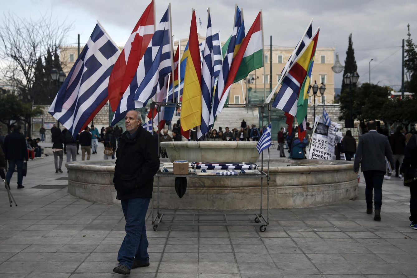 Un griego pasa ante banderas de la Unión en la Plaza Syntagma, en Atenas (Reuters).
