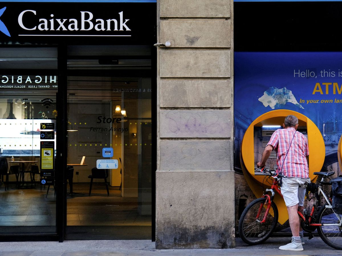 Foto: Un hombre en un cajero de Caixabank en Barcelona. (Reuters/Nacho Doce)