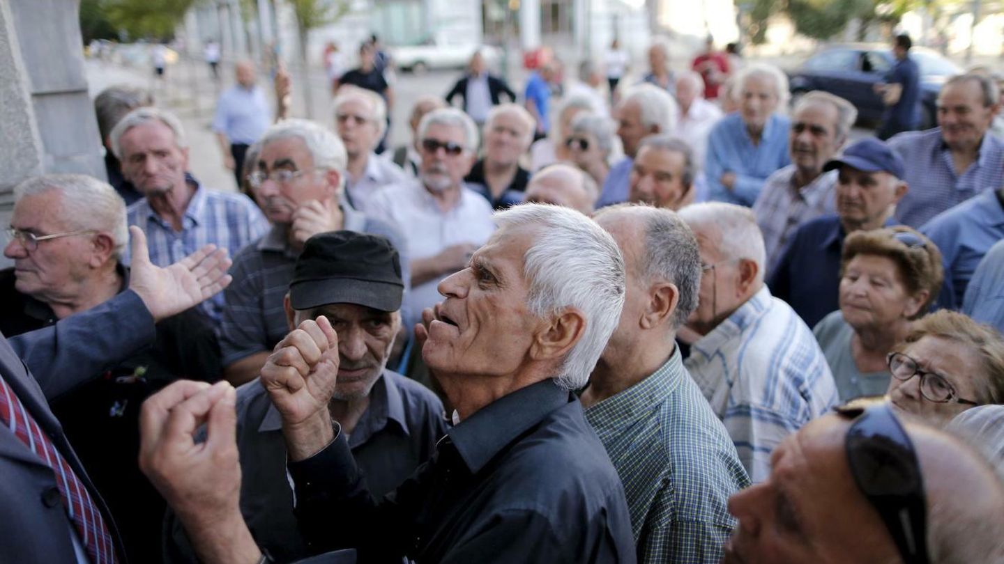 Un pensionista se enfrenta a un trabajador mientras intenta entrar en una sucursal del Banco Nacional de Grecia, en Atenas. (Reuters)