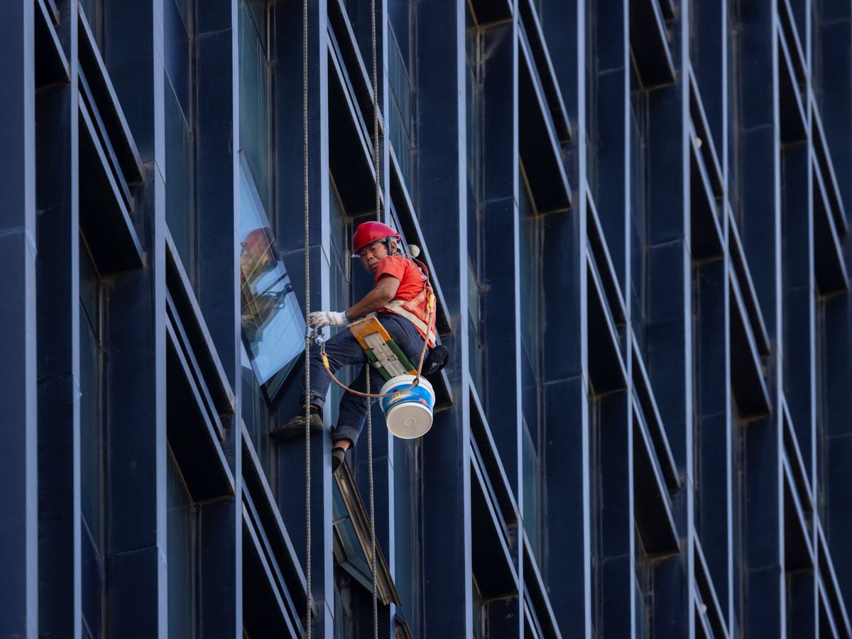 Foto: Un trabajador en un edificio de China. (EFE)