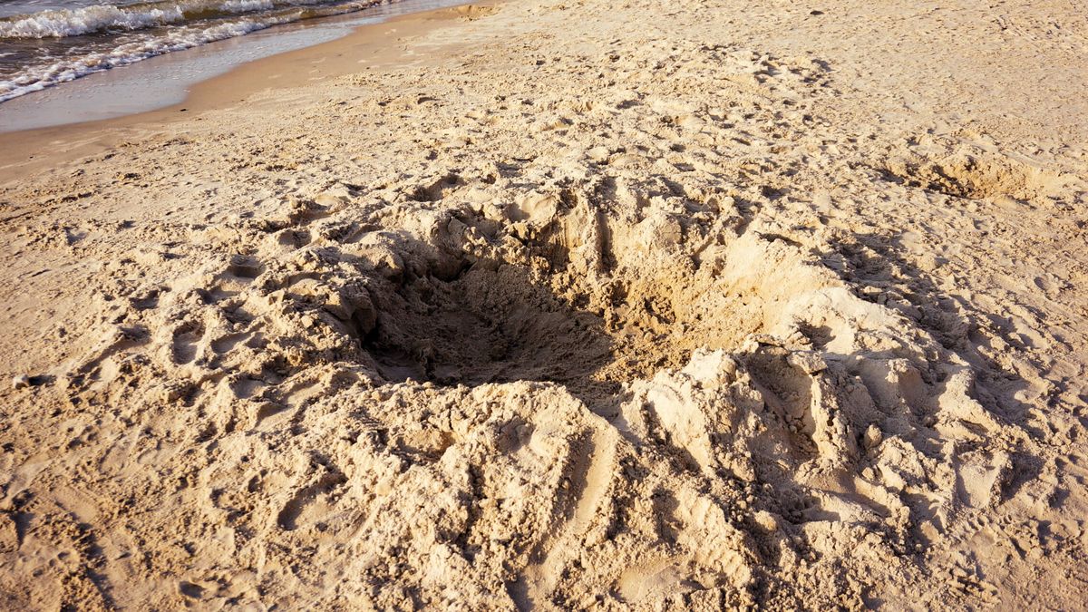 Por qué no deberías hacer agujeros en la arena de las playas este verano