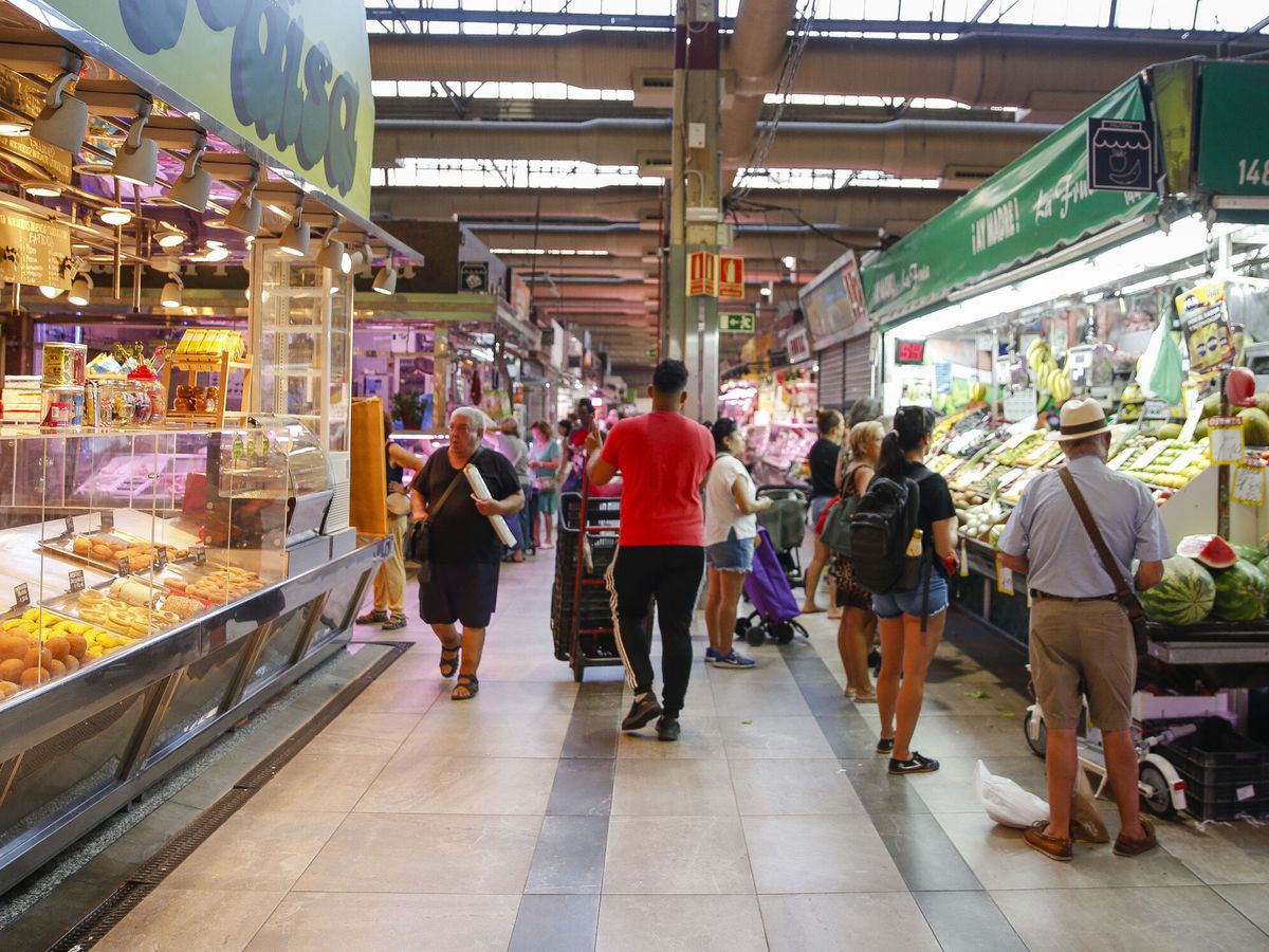 Foto: Varias personas hacen la compra en un mercado madrileño. (EFE/Víctor Casado)