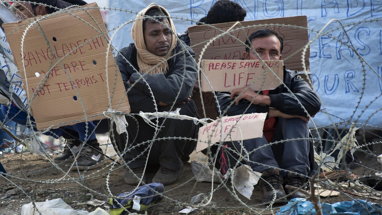 Foto: Varios refugiados esperan el permiso para cruzar la frontera entre Grecia y Macedonia. (EFE) 