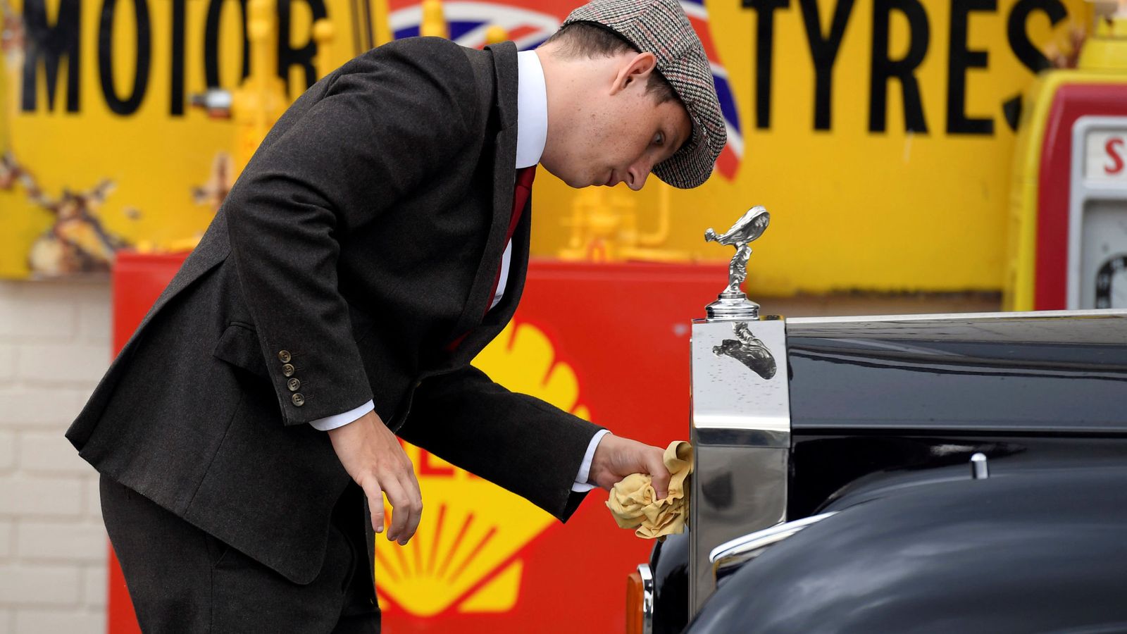 Foto: Un hombre limpia la carrocería de un Rolls Royce en el certamen de coches históricos de Goodwood, Inglaterra. (Reuters)