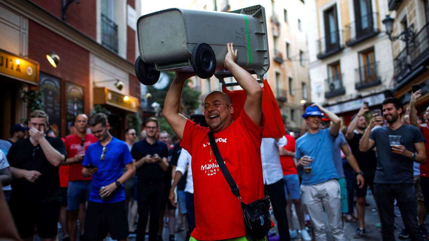Un seguidor del Liverpool carga con un cubo de basura en una calle de Madrid. (EFE)