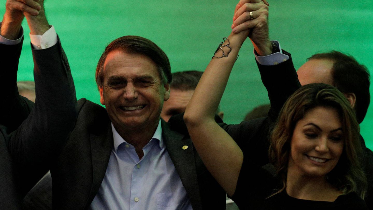 Bolsonaro levanta el brazo de la victoria junto a su esposa. (EFE)