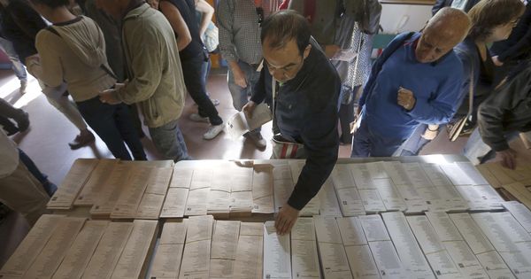 Foto: Varios ciudadanos eligen sus papeletas en un colegio electoral de Madrid, durante los últimos comicios municipales y autonómicas. (EFE)