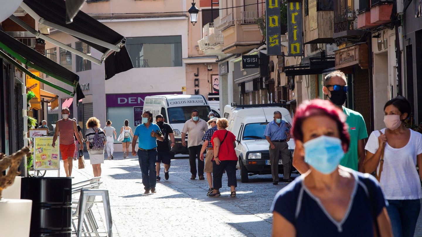 Varias personas protegidas con mascarilla caminan por la calle más comercial de Aranda. (EFE)