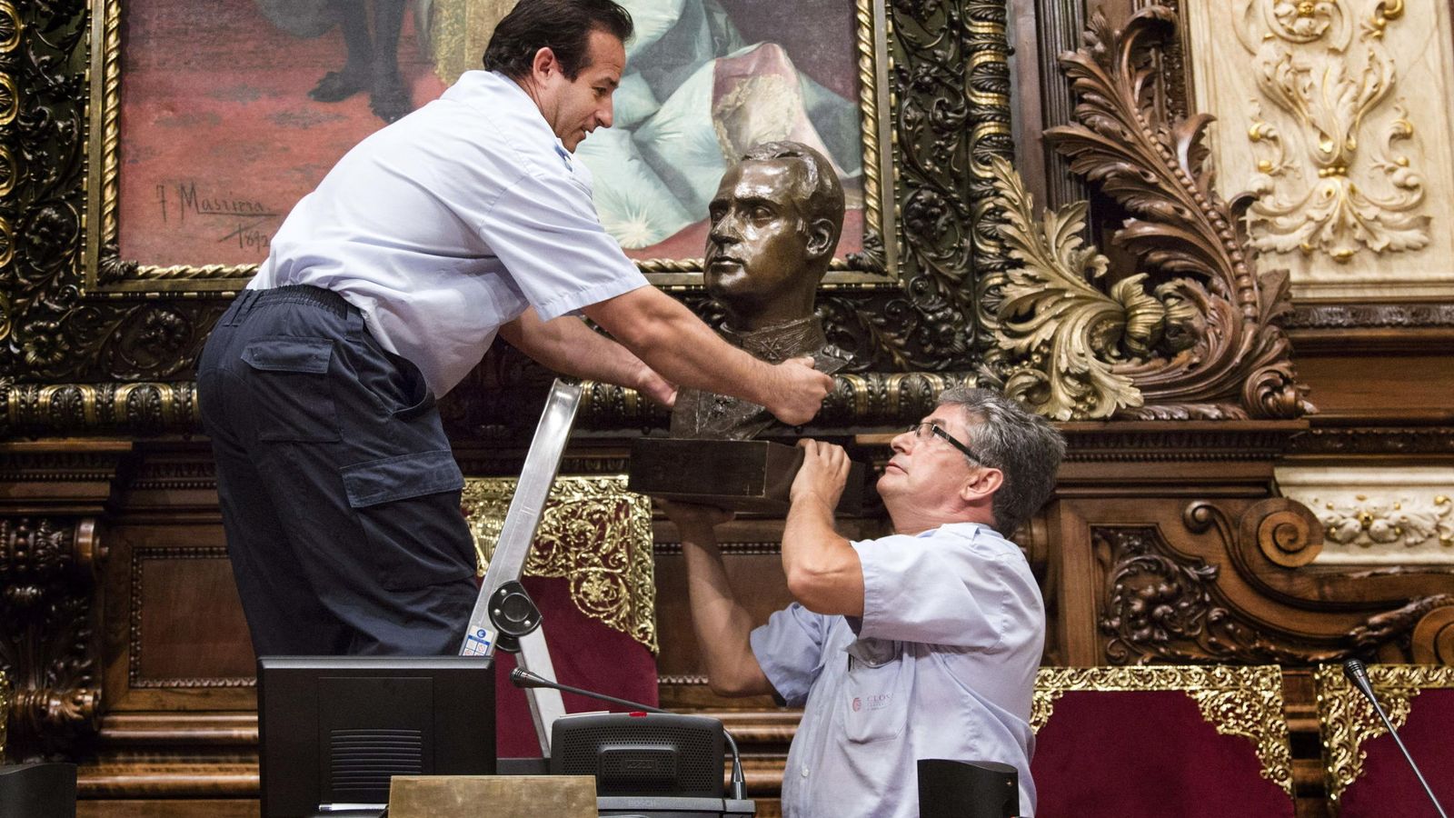 Foto: Dos operarios municipales retiran el busto del rey Juan Carlos I que había en el Salón de la Reina Regente. (EFE)