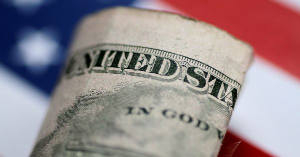 Foto: Un billete de 5 dólares frente a una bandera estadounidense. (Reuters)