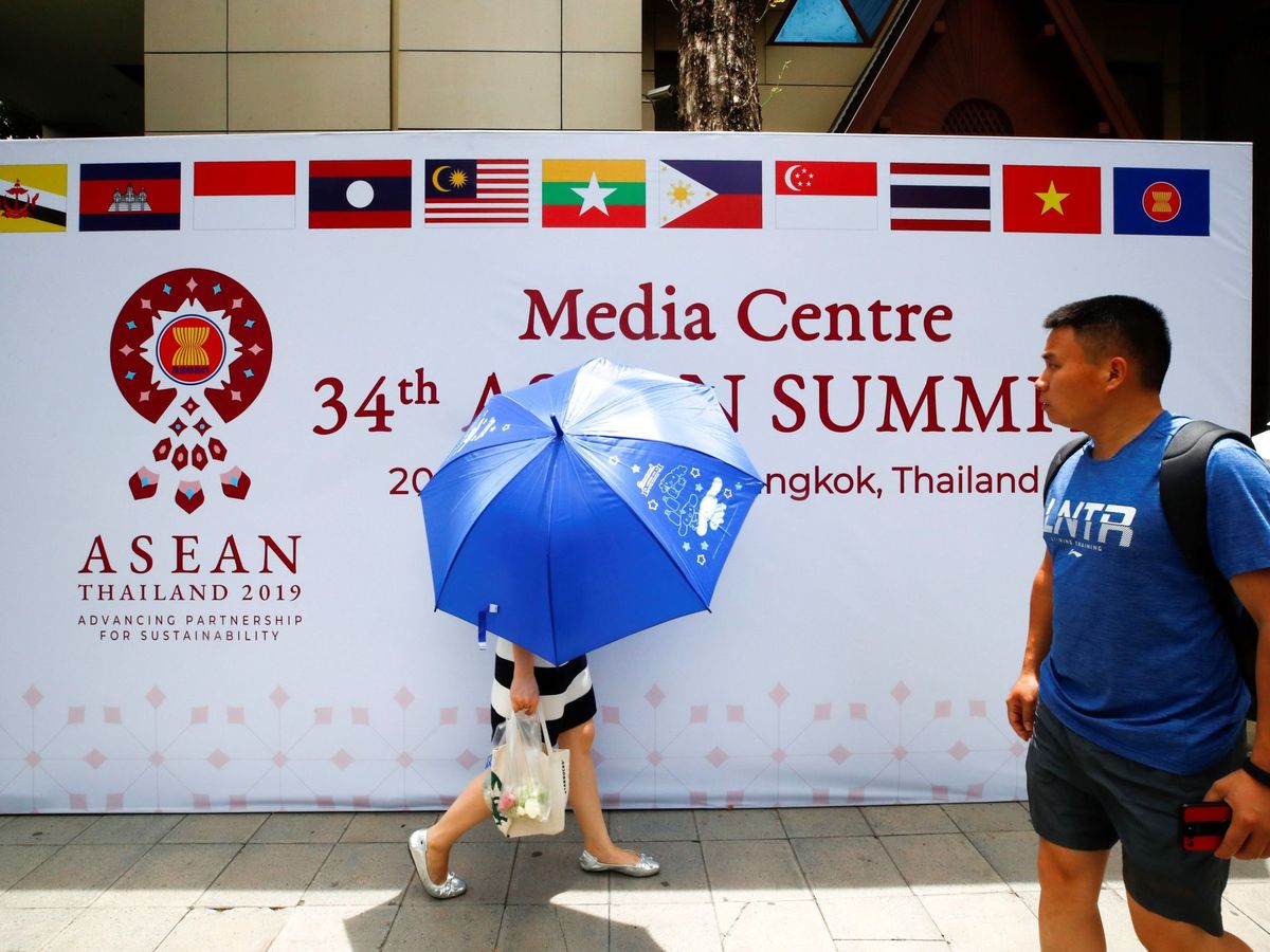Foto: Varios ciudadanos pasan por delante del centro de prensa para la 34º cumbre de la Asociación de Naciones del Sudeste Asiático (Asean). (EFE)
