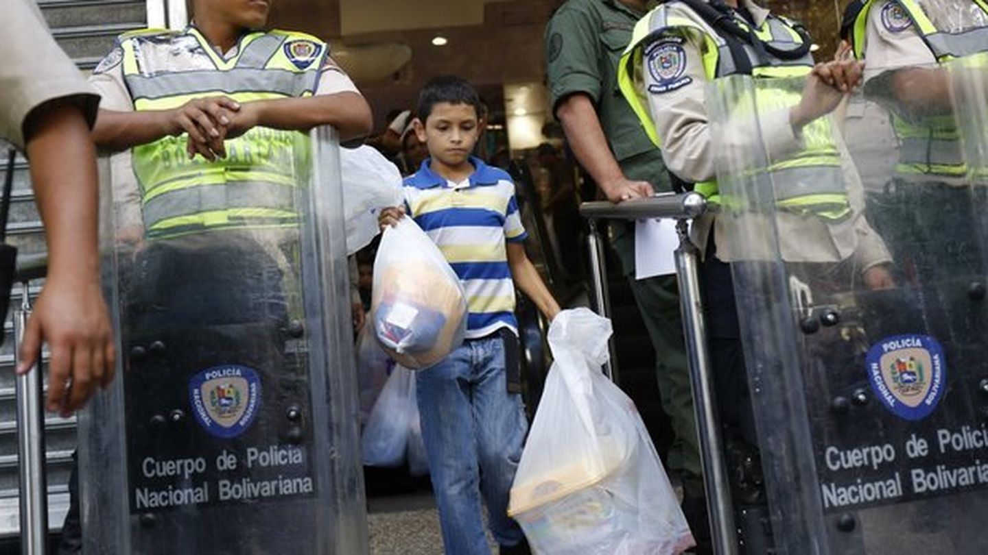 Un niño sale de un supermercado intervenido por el Gobierno de Maduro en Caracas (Reuters)